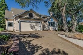 Home with a two-car garage under oak trees