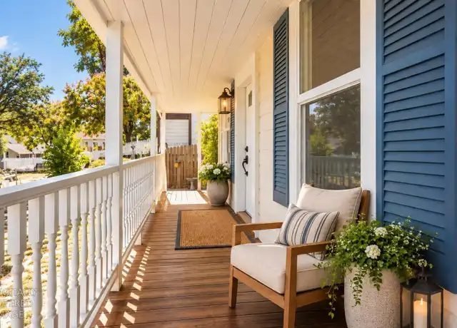 Covered front porch with a chair and white railing